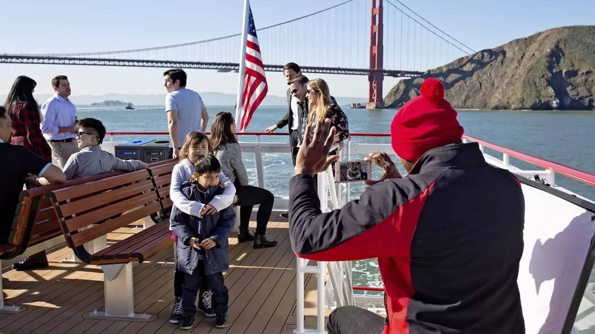 A family enjoys a cruise on the bay, passing the 金门大桥.