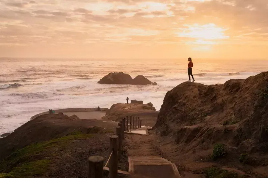 샌프란시스코의 수트로 배스(Sutro Baths)에서 바다가 내려다보이는 바위 위에 두 사람이 서 있습니다.