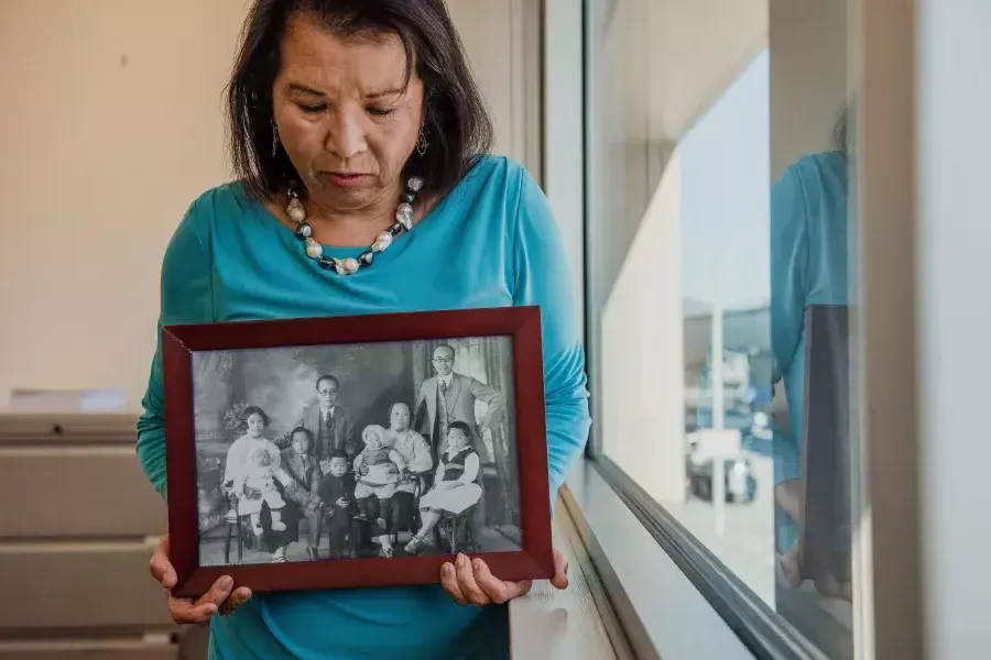 Melinda Yee Franklin holding a photograph of her family.