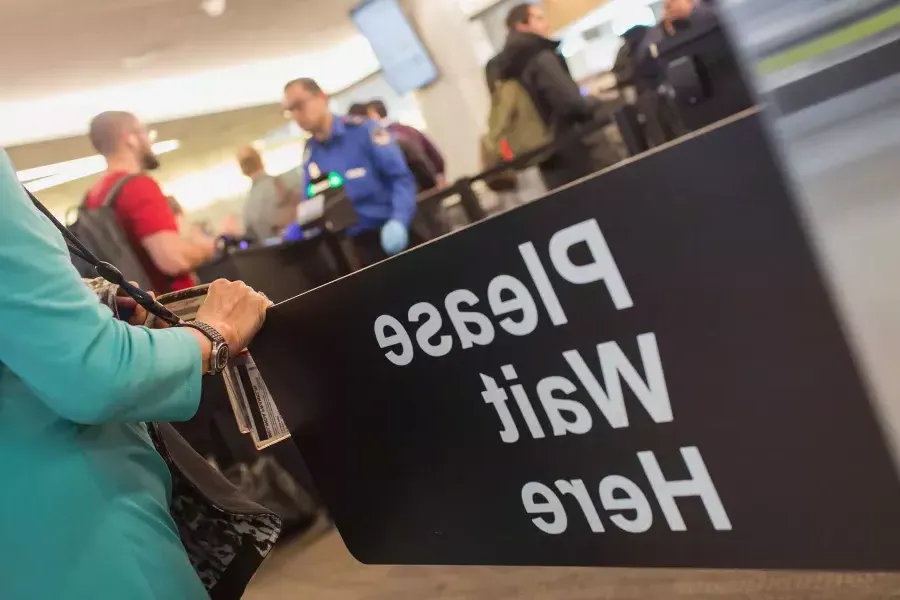 Please wait here sign at SFO security.