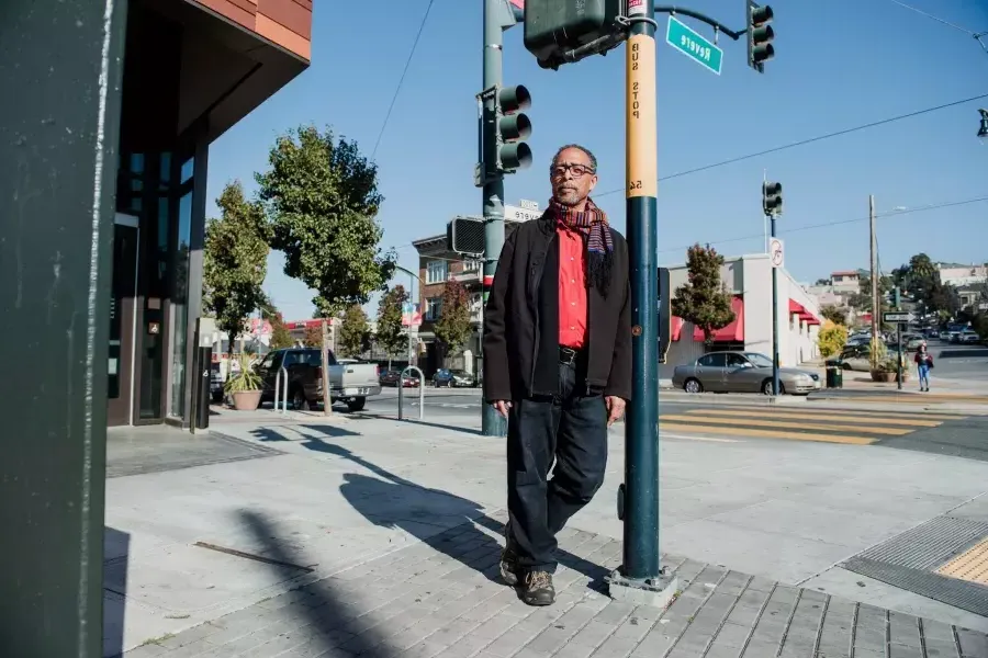 Ron Moultrie Saunders leaning against a pole.