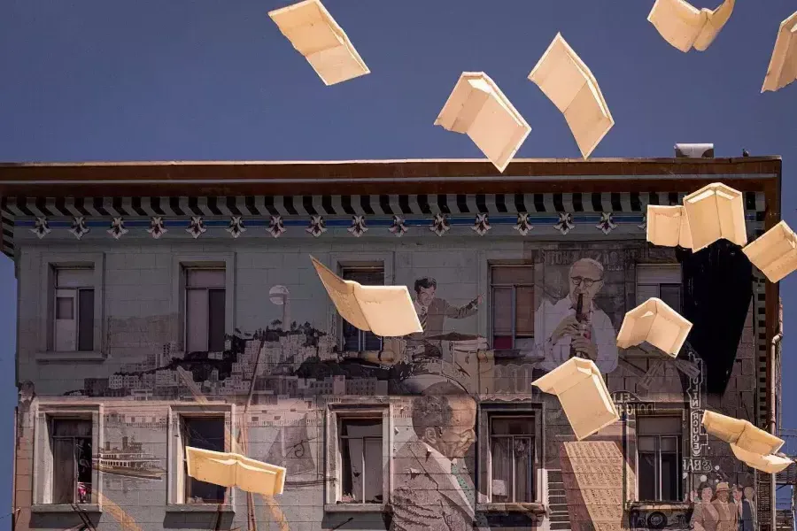 Exterior shot of City Lights Bookstore in San Francisco, showing a mural of books and floating paper.