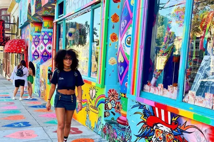 Una mujer camina por una calle con edificios coloridos en el barrio Haight-Ashbury de San Francisco.