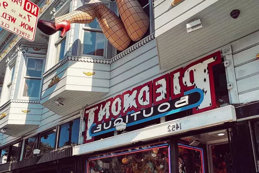 A pair of mannequin legs wearing fishnet stockings hang out of a window over Haight Street at Piedmont Boutique. 贝博体彩app，加利福尼亚.