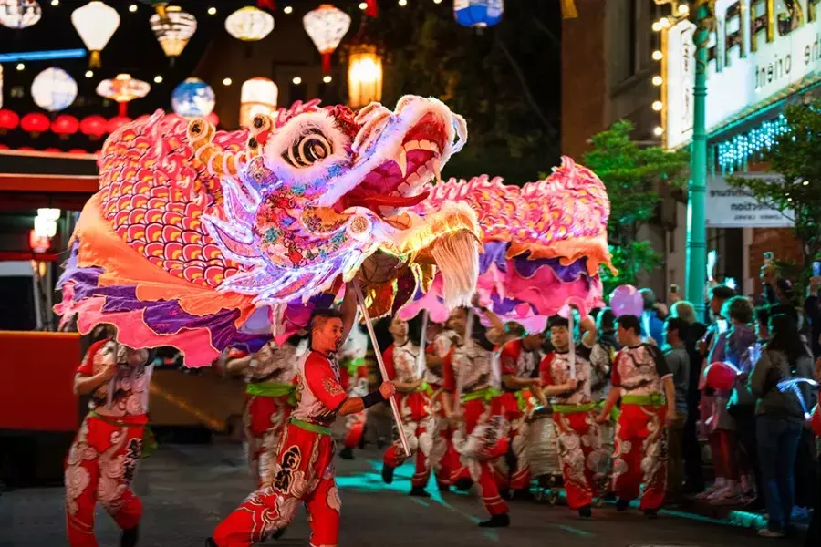 Tänzer manipulieren während der Lunar New Year Parade in San Francisco einen riesigen, beleuchteten Drachen.