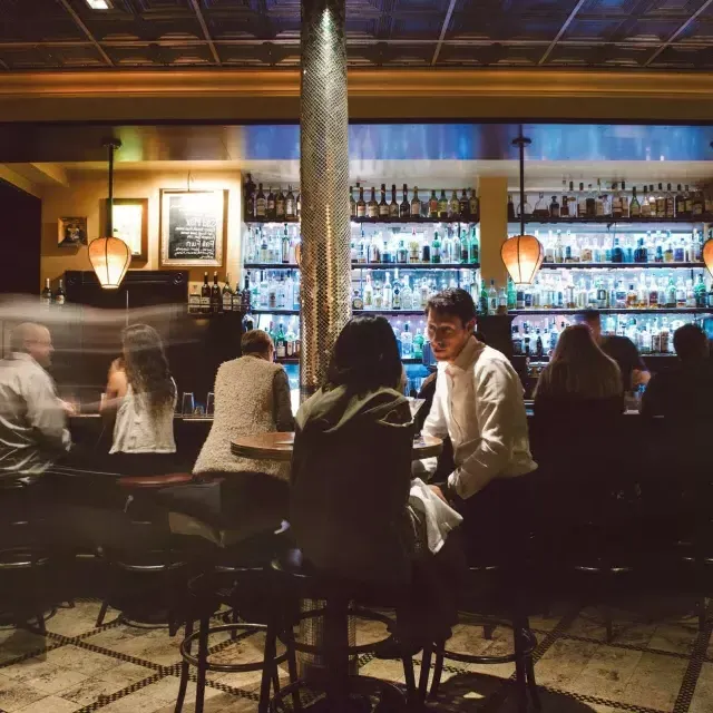 Un couple partage un verre dans un bar animé de 贝博体彩app.